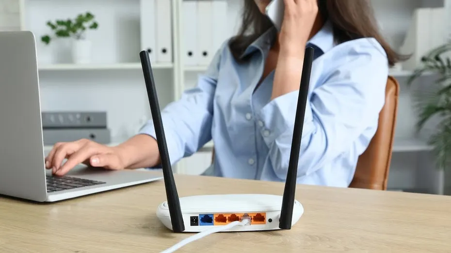 A Wi-Fi router with glowing signal waves and a broken padlock symbolizing a security vulnerability.
