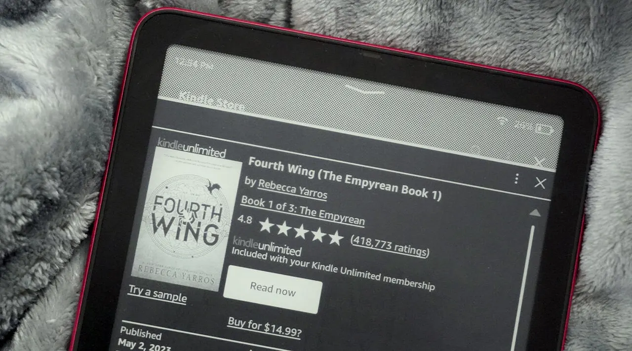 A Kindle e-reader beside headphones, representing the Kindle+ subscription and its expanded audiobook catalog.