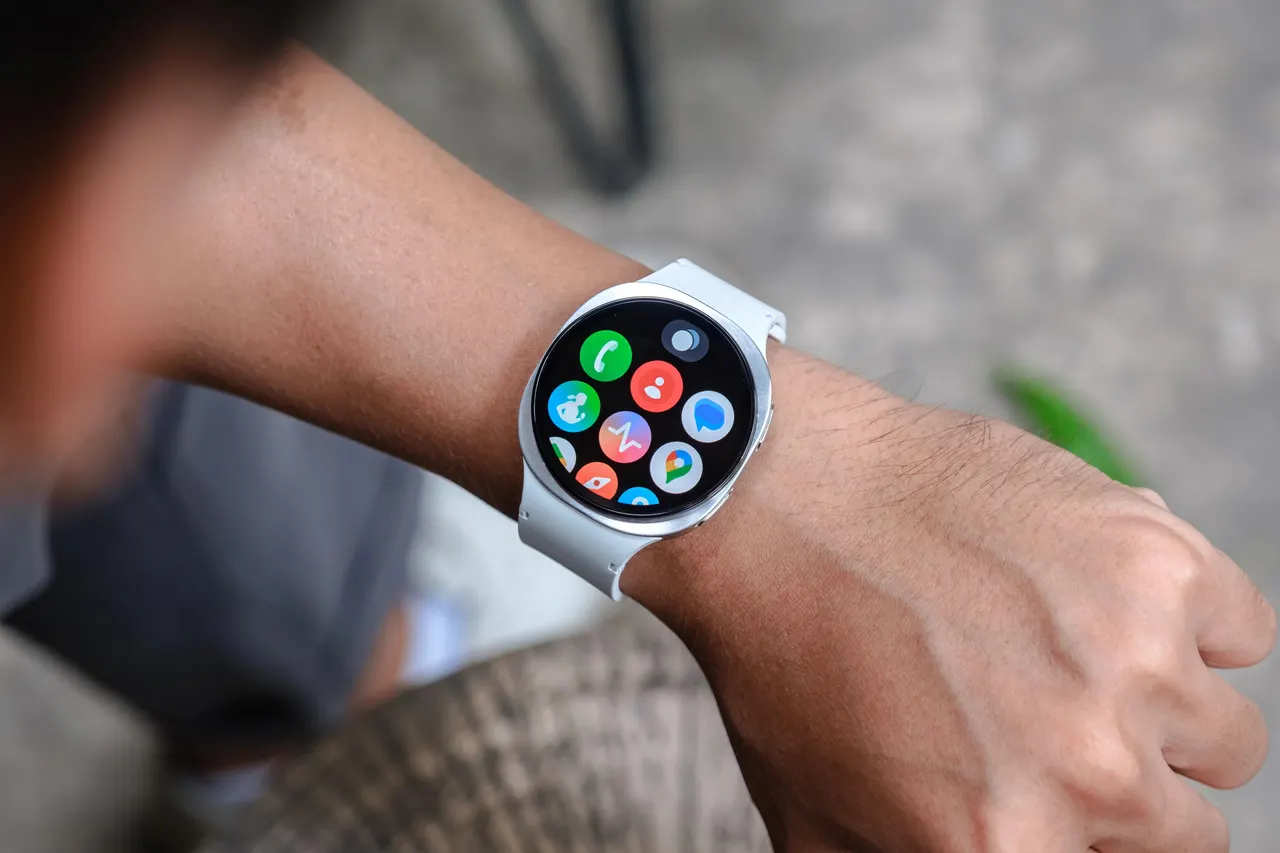 A Samsung Galaxy Watch worn on a wrist, with the sensor side that touches the skin in focus.