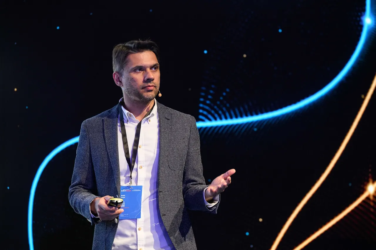 A startup founder presents an AI-powered document workspace showing slides, narrative and data model tabs on a laptop screen.