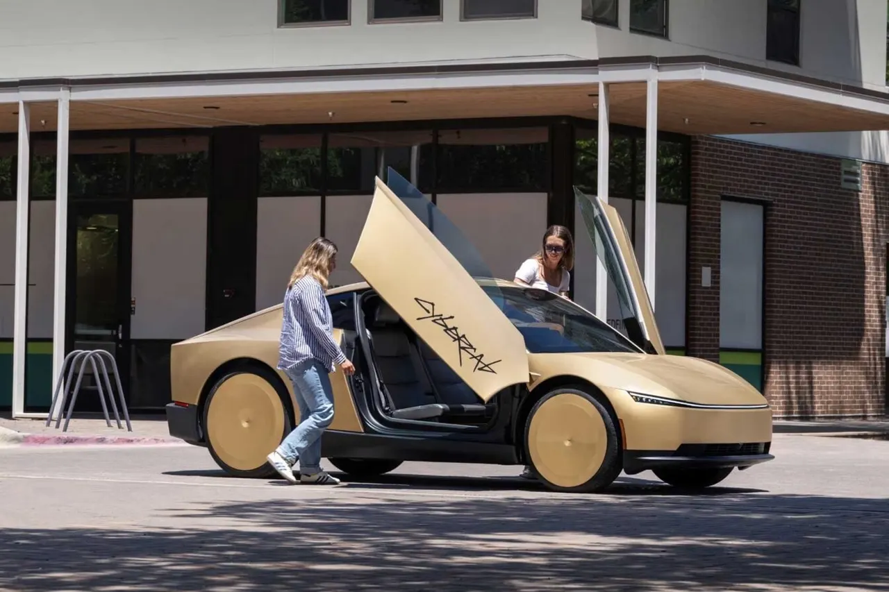 A Tesla Cybercab, a two-seat autonomous vehicle with no steering wheel or pedals, displayed on a stand at an auto show.