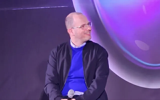 Two developer platform logos facing off on a stage, representing the rivalry between Entire and GitHub over AI-driven code hosting.