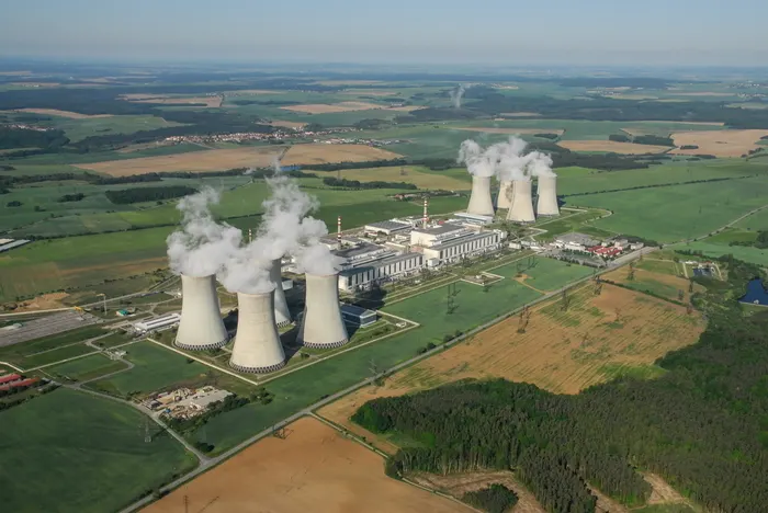 Nuclear power plant cooling towers under a cloudy sky, representing the Dukovany reactor project in the Czech Republic.