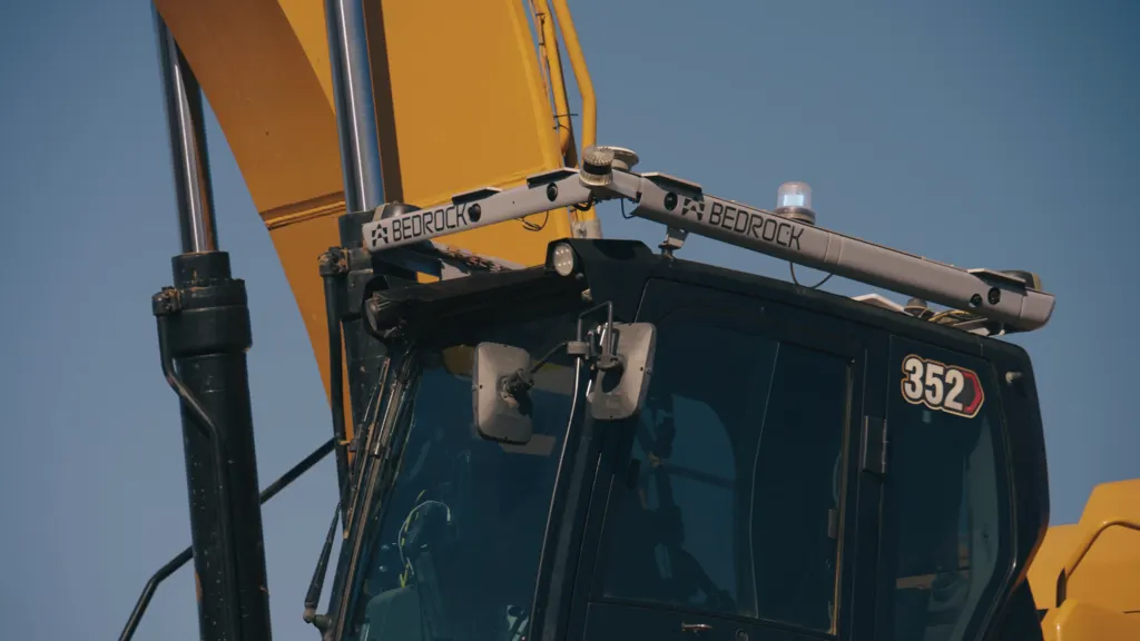 An autonomous excavator fitted with lidar and sensors digging at a construction site.