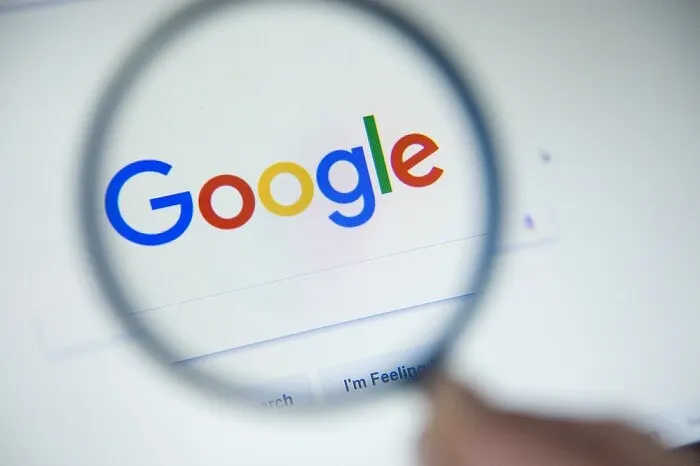 Google logo on a building facade with a Russian court gavel and ruble banknotes in the foreground.