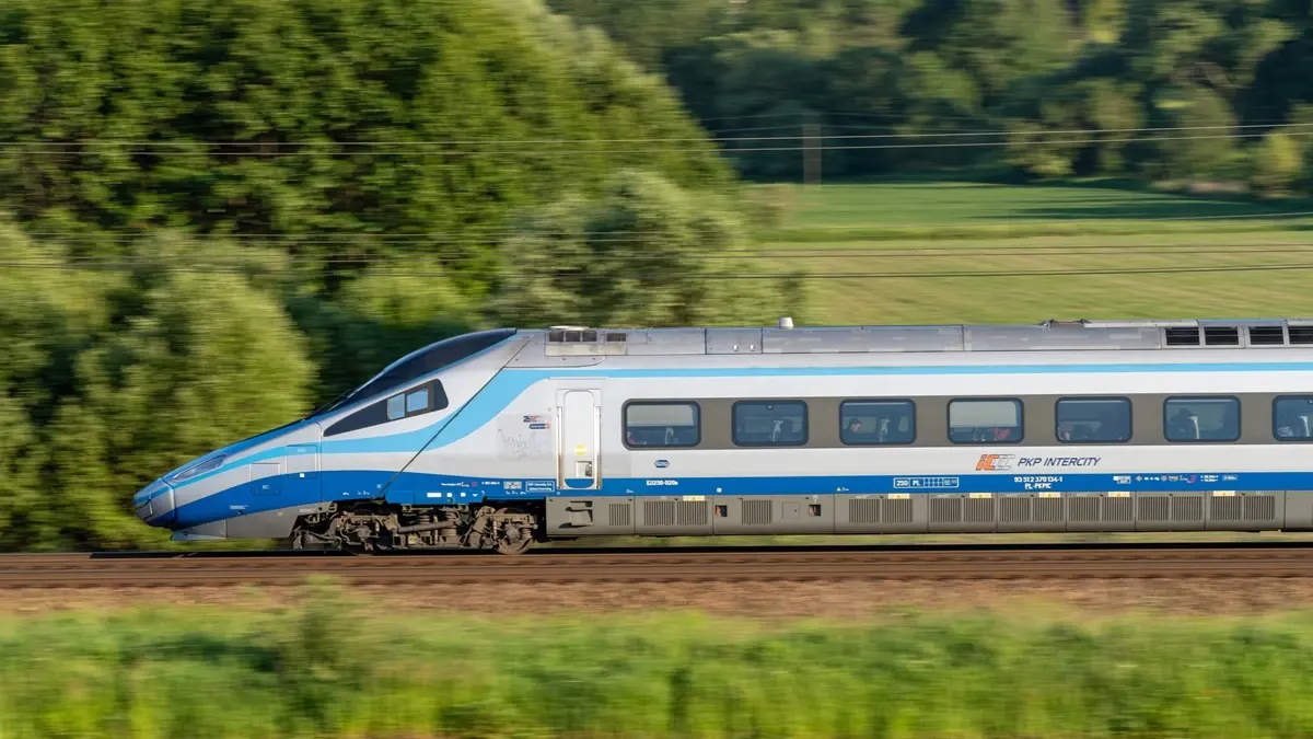 A PKP Intercity Pendolino high-speed train traveling through the Polish countryside.