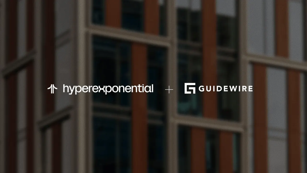 Insurance professionals reviewing risk and pricing data on a screen with AI-driven analytics, illustrating Guidewire's acquisition of Hyperexponential.