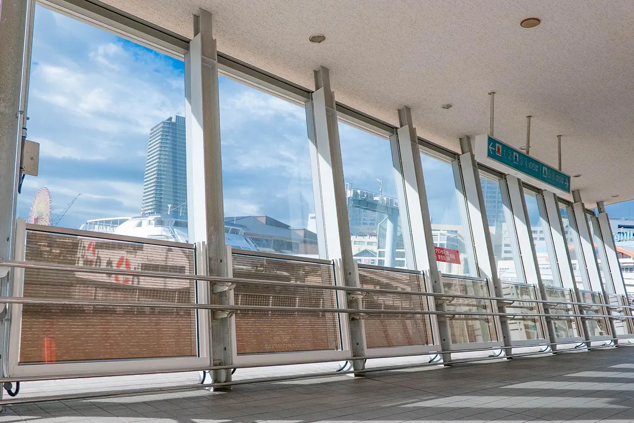 Wave-patterned perovskite solar glass panels installed at a harbor terminal entrance in Kobe, Japan.