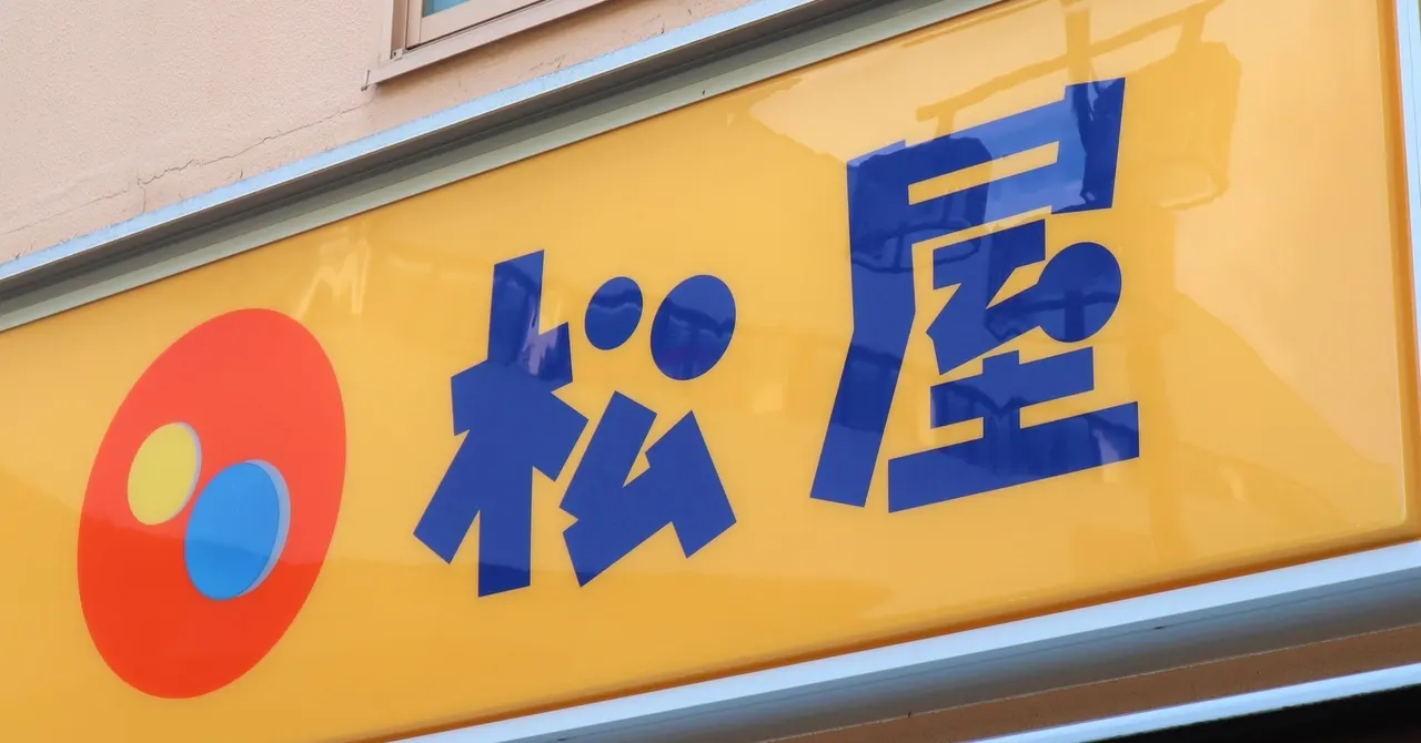 Smartphone showing a food-ordering app with a warning symbol, representing the Matsuya app data breach.