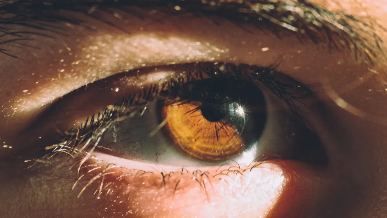 A robotic micromanipulator positioned over a model of a human eye in a research laboratory.