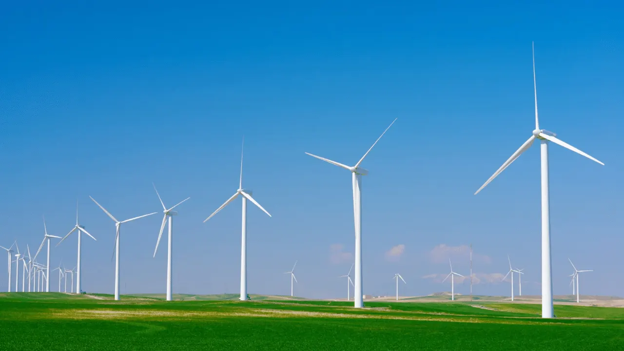 Wind turbines and solar panels in the Polish countryside symbolising investment in clean energy technologies.