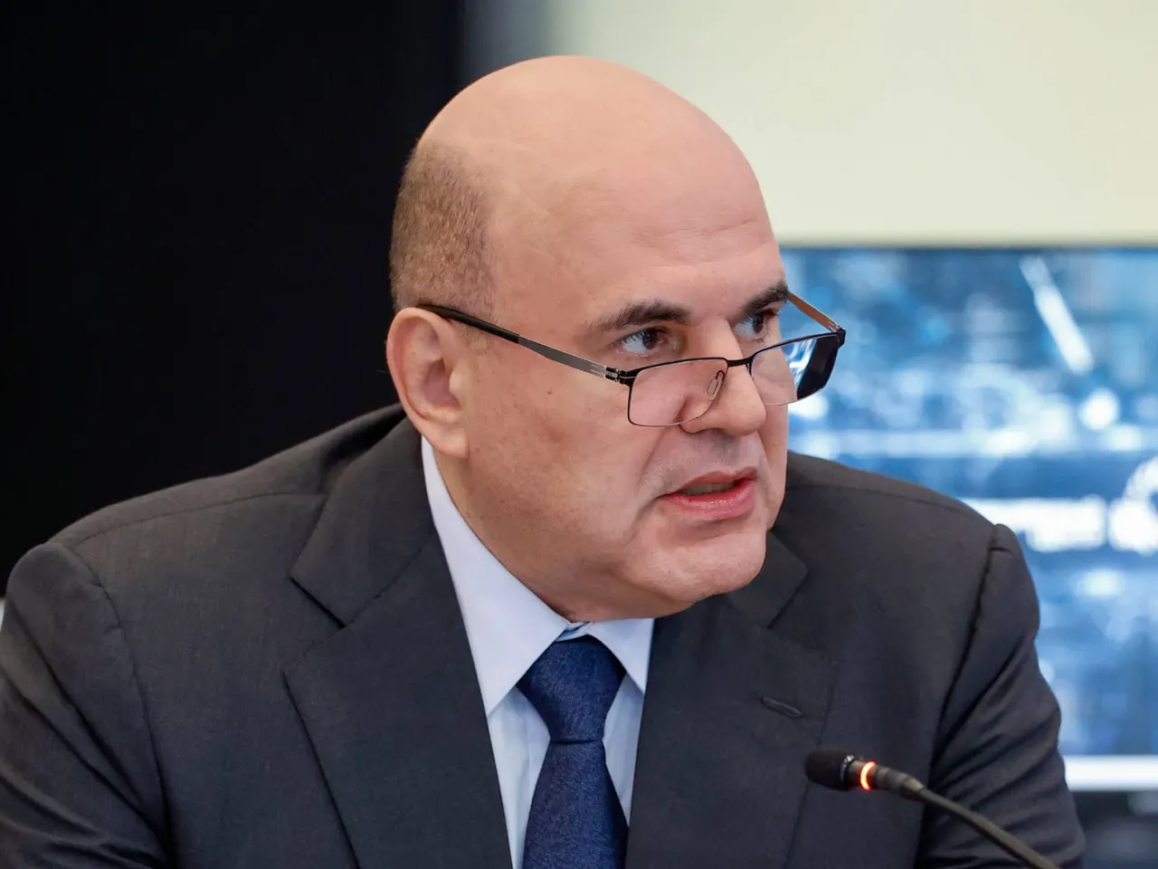 Speaker addressing delegates at a digital technology forum in Kazan, with screens showing IT industry statistics.
