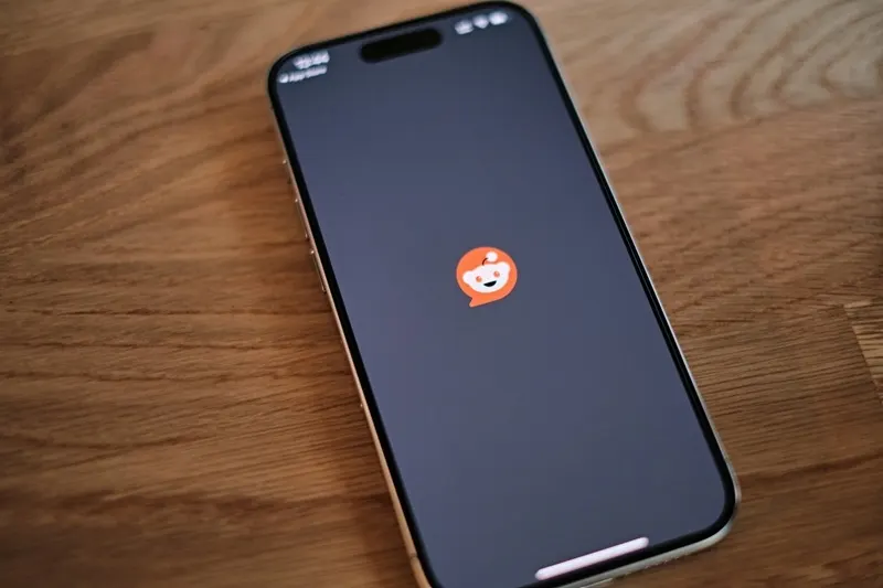 Reddit logo on a smartphone screen next to a login prompt