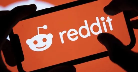 Reddit logo on a smartphone screen next to a login prompt, symbolizing the platform's move to require accounts.