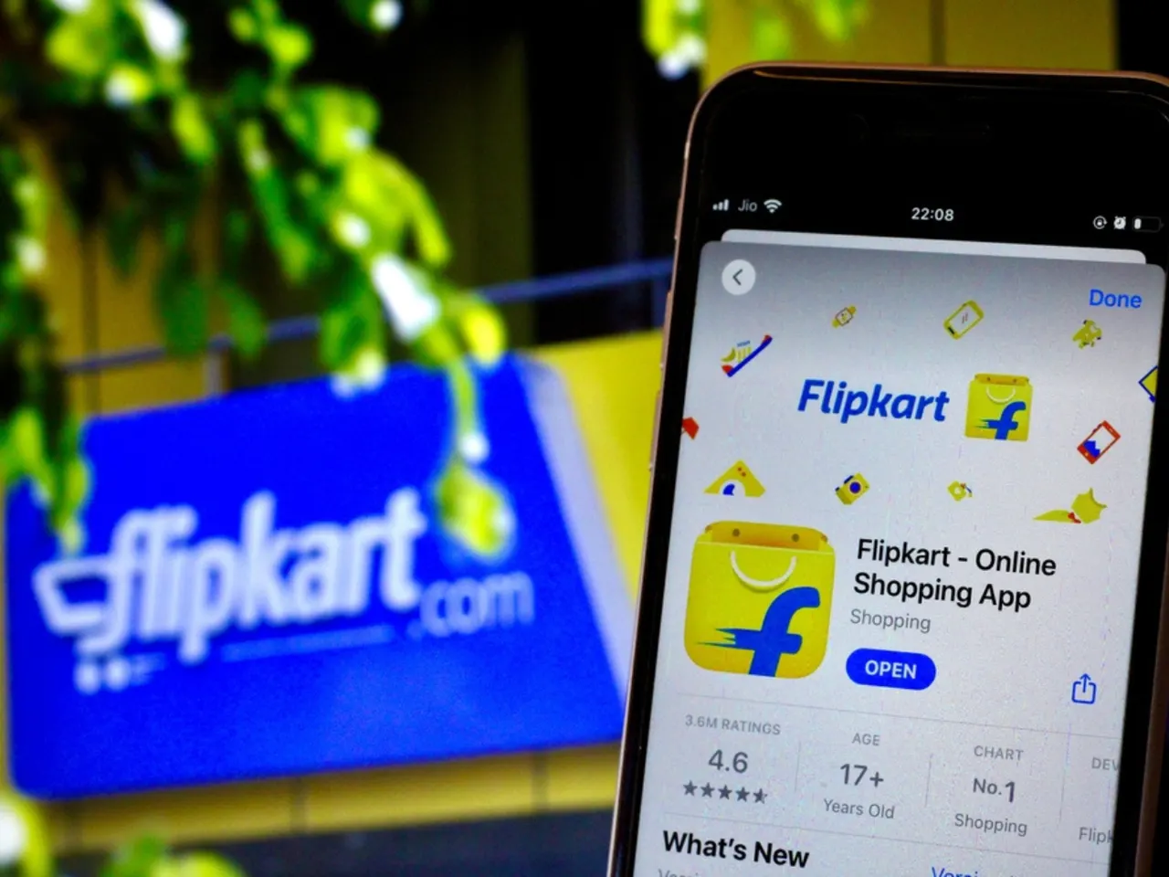 Flipkart logo on a smartphone screen in front of a Walmart storefront, illustrating the corporate investigation.
