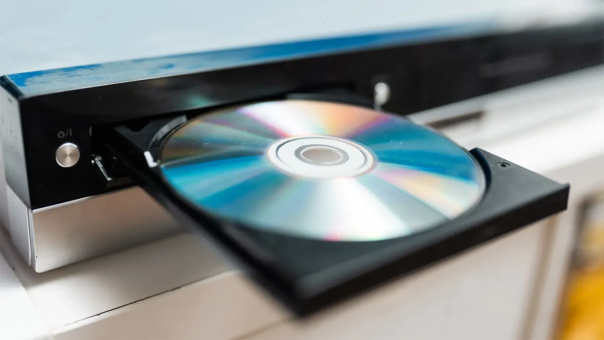 A black Sony Ultra HD Blu-ray player placed beneath a television in a home cinema setup.