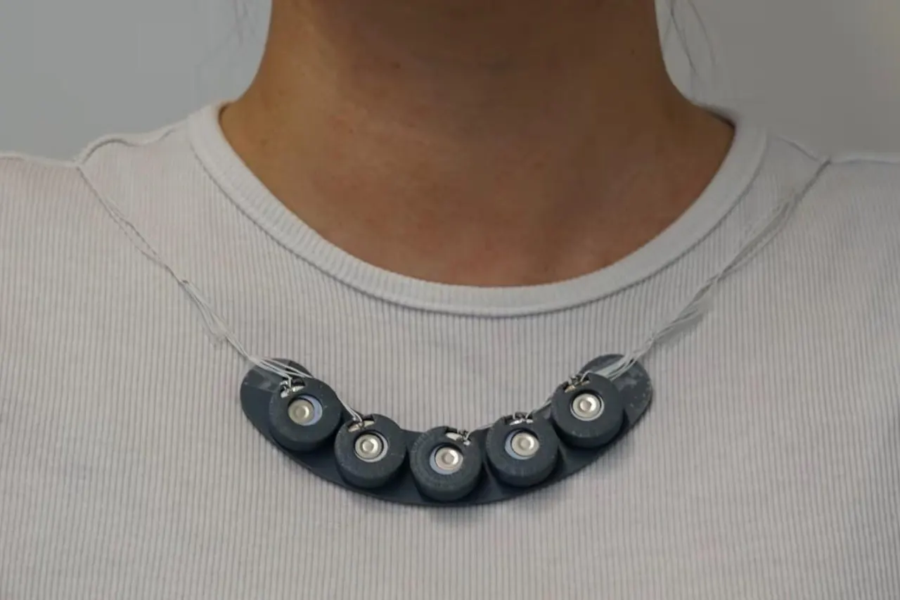 A wearable scent-release device next to a cup of coffee, illustrating a system that sends smells over the internet.