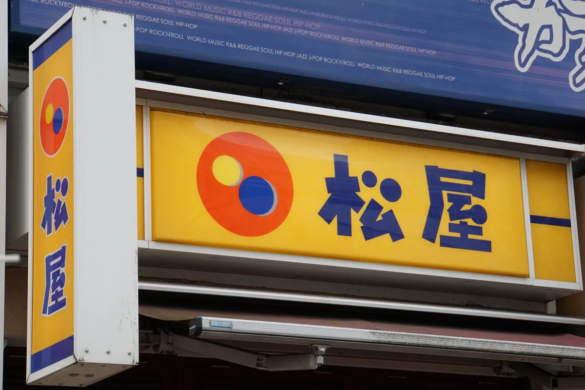 A Matsuya restaurant ticket vending machine beside a smartphone showing a suspended app, illustrating the data breach.