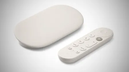 Google TV Streamer 4K streaming box next to a remote control in front of a television.