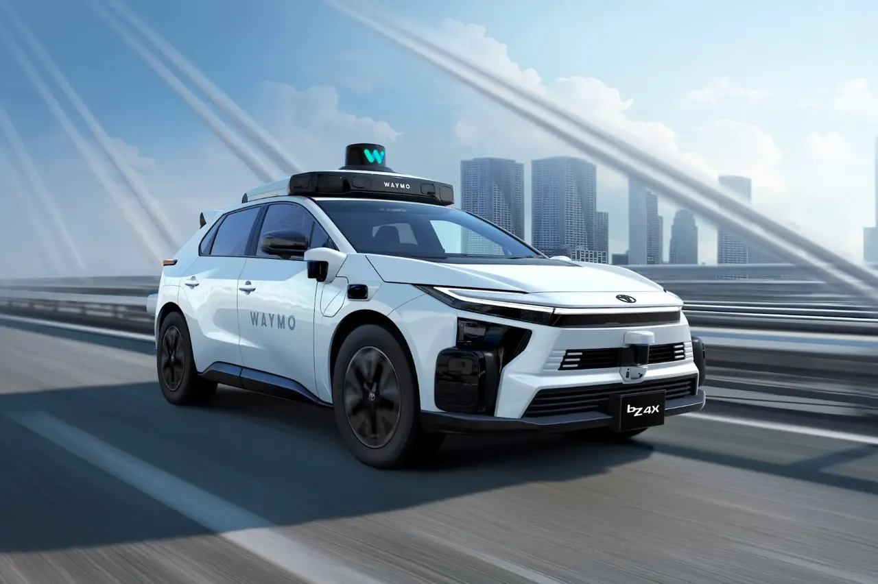 A white Toyota bZ4X electric SUV fitted with autonomous driving sensors on a city street in Japan.